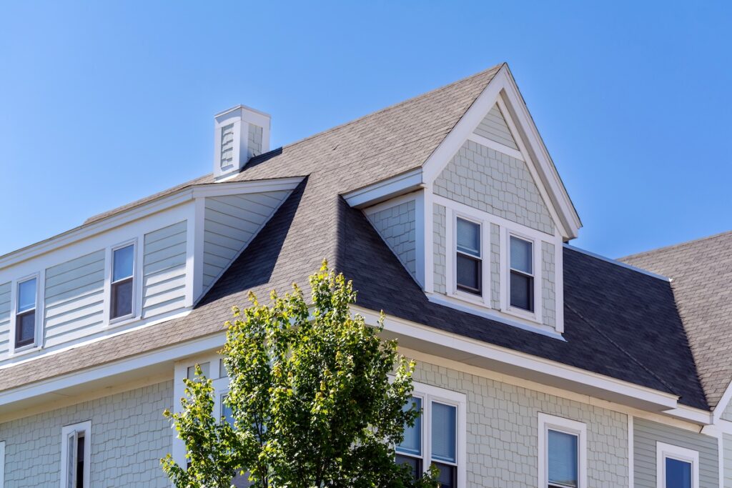 roofing canton oh Dormer windows on the sloped shingle roof of a newly built house in Brighton, Massachusetts, USA