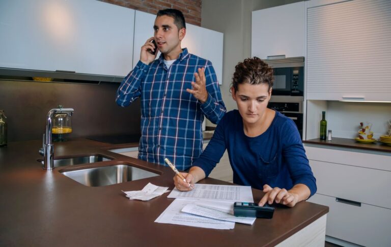 roof insurance claim young people talking on the phone calculator