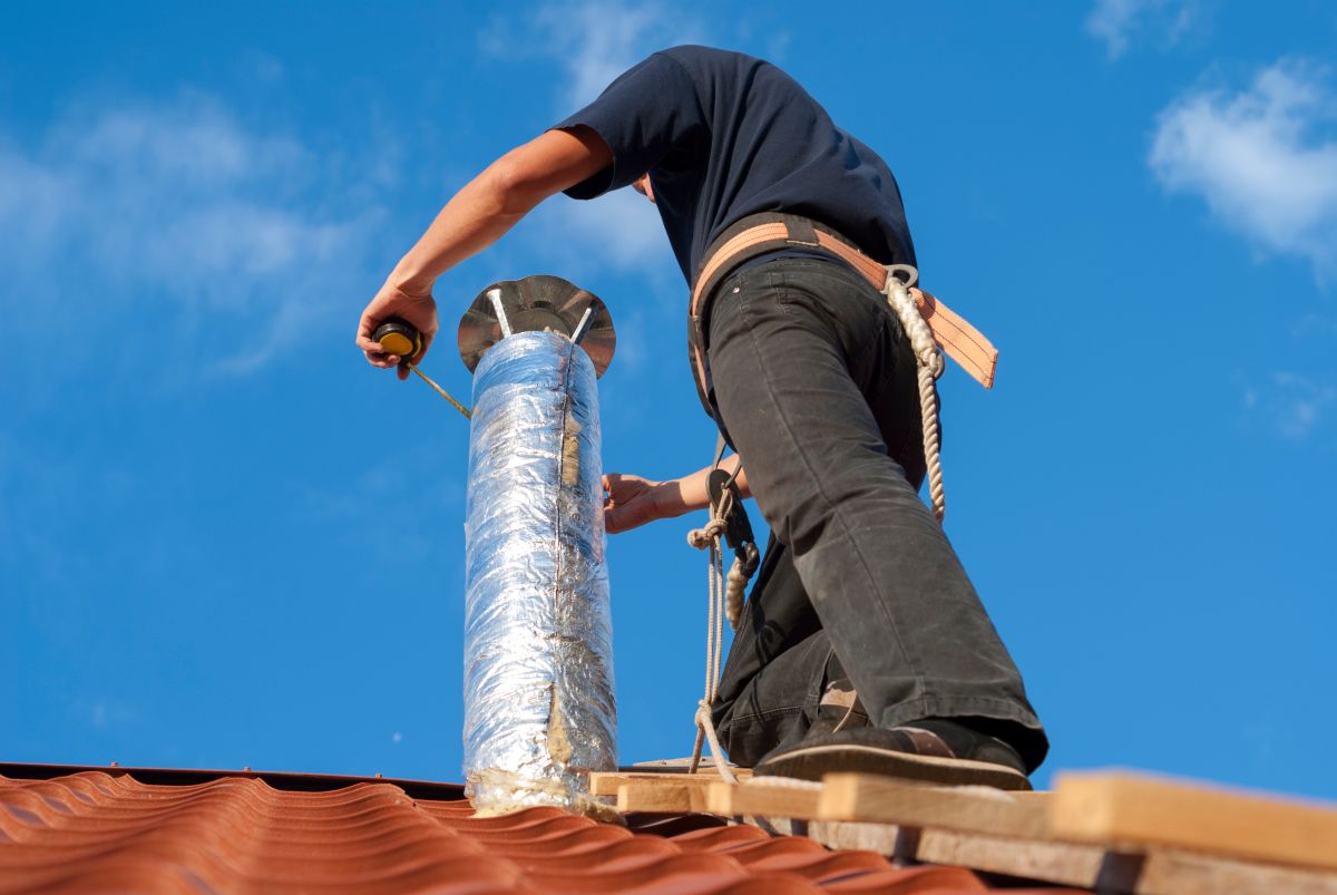 attic vent installation worker installing pipe